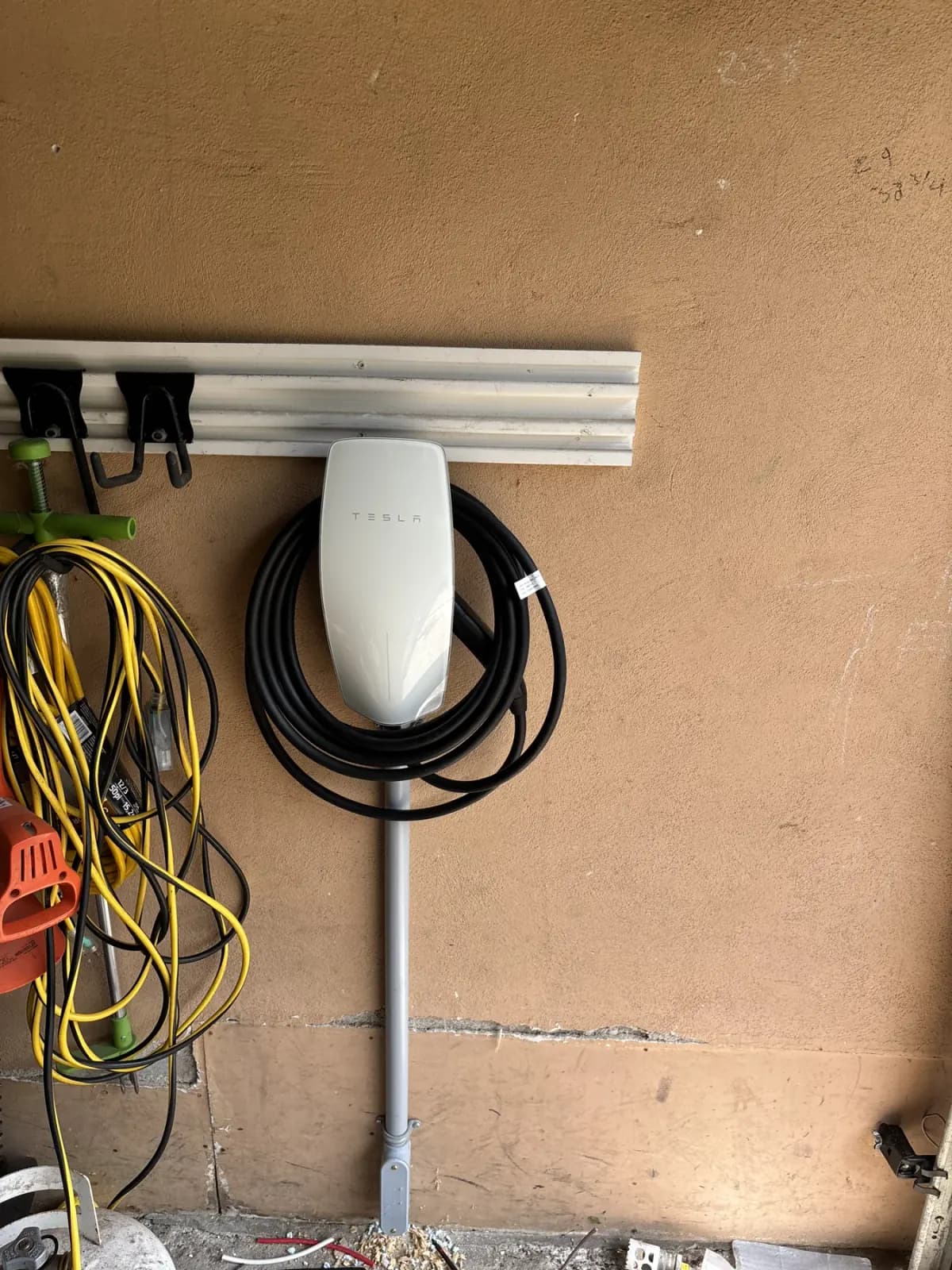 Tesla charger with surface conduit in a garage, installed by Levere Electric